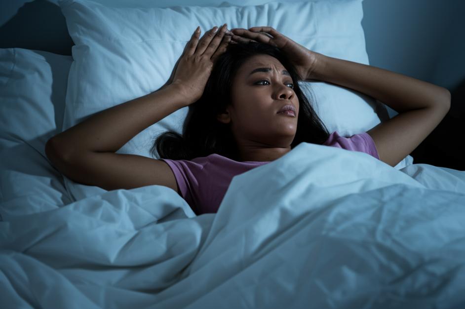 Người phụ nữ trằn trọc trên giường vì mất ngủ.