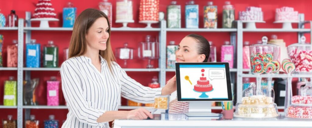 Chủ cửa hàng bánh kẹo sử dụng phần mềm quản lý khách hàng trên máy tính bảng.