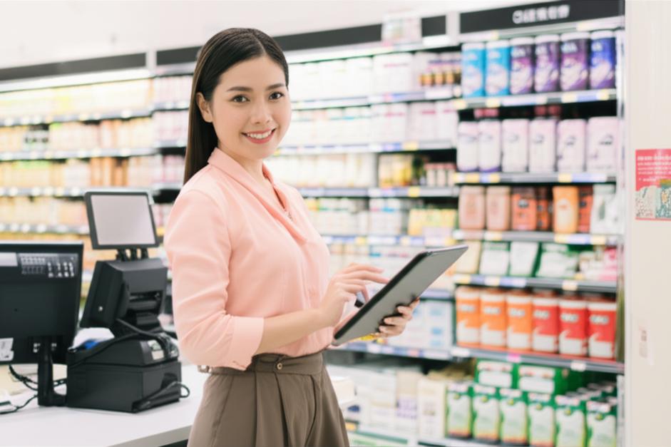 Người phụ nữ tự tin quản lý cửa hàng hiện đại với phần mềm bán hàng.