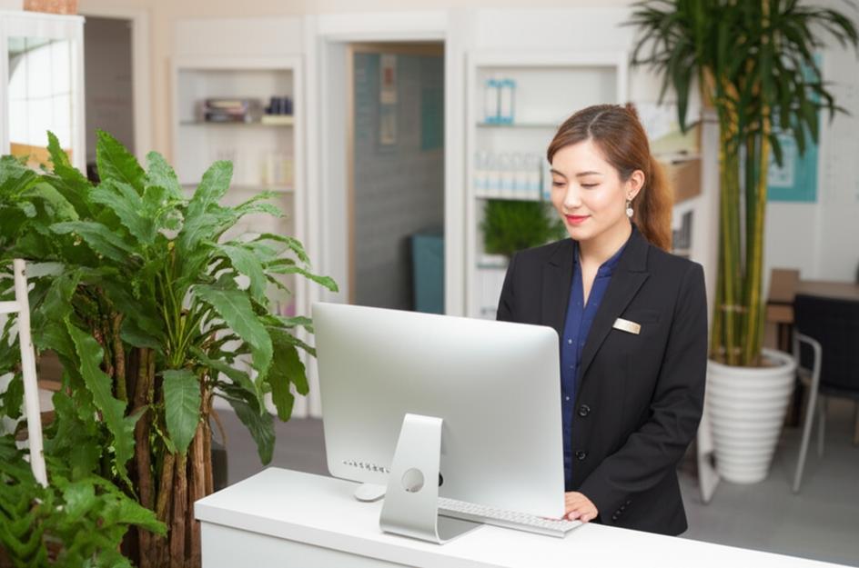 Nhân viên lễ tân beauty salon sử dụng phần mềm quản lý khách hàng trên máy tính.